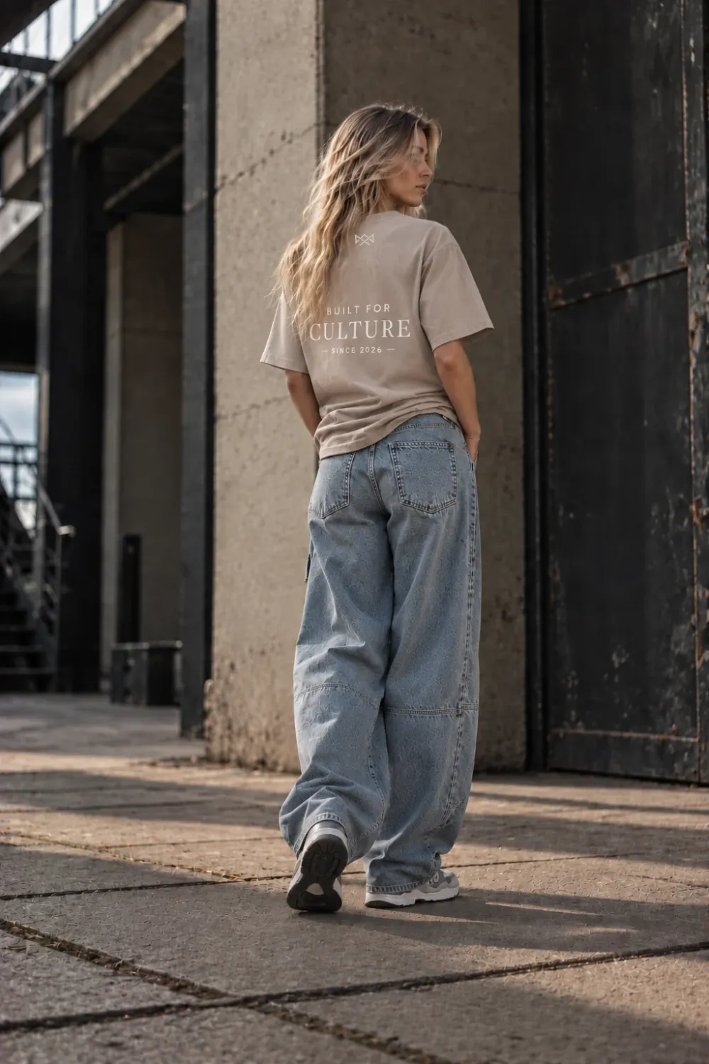 Model draagt Built For oversized T-shirt beige met Built For Culture opdruk, achterkant