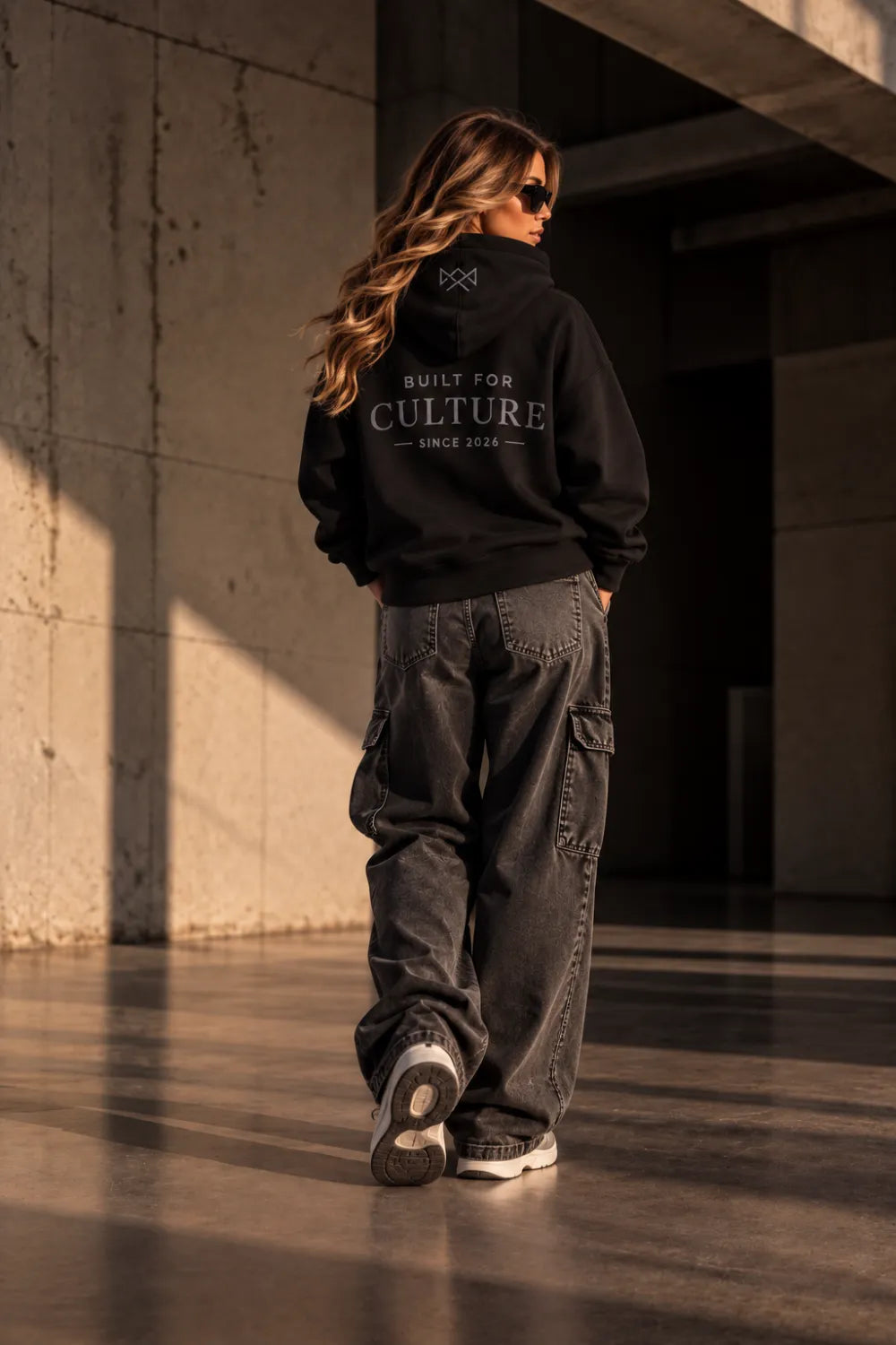 Model draagt Built For oversized hoodie zwart met Built For Culture opdruk, achterkant